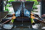 Close up of bamboo water hand washing basins at a Japanese Shinto Shrine.