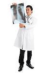 Full length attractive young male Southeast Asian medical doctor examining xray scan image, standing isolated on white background.