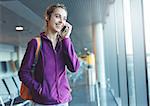 Girl at the airport window talking by phone