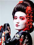 young pretty geisha in black kimono among sakura, asian ethno close up concept
