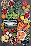 Healthy food for good health concept with super food of sardines, crevettes, fruit, vegetables, herbs and spice. Foods very high in antioxidants, anthocyanins, omega 3 fatty acids, fiber and vitamins.