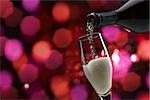 Pouring sparkling white wine into a wineglass, wine tasting and celebration concept