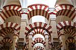 Double red-and-white colored arches inside the Mezquita Mosque and Cathedral in Cordoba, Andalusia, Spain