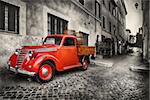 Red retro car on the street of Trastevere in Rome, Italy