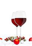Red wine glasses with christmas decoration on white background