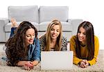 Happy teen girls studying at home with a laptop