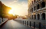 Colosseum and road at morning sunlight in Rome, Italy