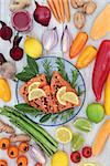 Super food for a healthy heart concept with fresh salmon, fruit, vegetables, nuts, beetroot smoothie, herbs and spices. Health food high in omega 3, antioxidants, anthocyanins, minerals and vitamins.