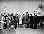 1920s AVIATRIX AMELIA EARHART & AVIATOR CHARLES LINDBERGH & WIFE ANNE STANDING BY FORD TRI-MOTOR AIRPLANE WITH GROUP OF PEOPLE