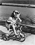 1930s 1940s GIRL RIDING TRICYCLE ON SIDEWALK