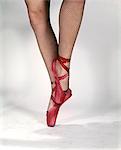 1960s WOMAN DANCER FROM KNEES DOWN ON POINTE WEARING BLACK FISHNET STOCKINGS AND RED BALLET SHOES