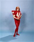 1970s WOMAN SMILING WEARING EXTRA LARGE RED FOOTBALL JERSEY RED LEOTARDS HALLOWEEN COSTUME HOLDING FOOTBALL LOOKING AT CAMERA
