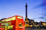 Red bus passing Nelson's Column in Trafalgar Square, London, England, United Kingdom, Europe