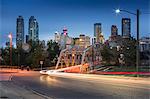 Car trail lights through Macdonal Avenue bridge and Downtown skyline at dusk, Calgary, Alberta, Canada, North America