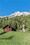 La Valle / Wengen, Alta Badia, Bolzano province, South Tyrol, Italy. Hikers traveling on the pastures of Pra de Rit