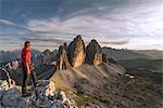 Sesto / Sexten, province of Bolzano, Dolomites, South Tyrol, Italy. A mountaineer admires the sunset at the Three Peaks of Lavaredo