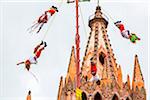 The Danza de los Voladores (Dance of the Flyers) or Palo Volador (pole flying) by the Totonac tribe performing in front of the Parroquia de San Miguel Arcangel at the St Michael Archangel Festival in San Miguel de Allende, Mexico