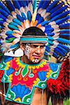 Close-up portrait of a male, indigenous tribal dancer wearing a feathered headress in the St Michael Archangel Festival parade in San Miguel de Allende, Mexico