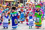 People walking in the St Michael Archangel Festival parade in colorful costumes in San Miguel de Allende, Mexico