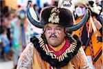 Close-up portrait of a male, indigenous tribal dancer wearing fur hat with horns in the St Michael Archangel Festival parade in San Miguel de Allende, Mexico