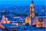 The 18 century Church of San Francisco (formerly the Convent of San Antonio) with the prominent bell tower and overview of city at dusk in San Miguel de Allende, Mexico