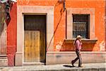 Man walking down street in front of traditional buildings in San Miguel de Allende, Mexico