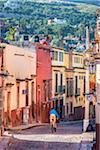 Person bicycling on traditonal cobblestone street in San Miguel de Allende, Mexico