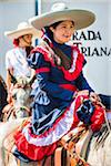 Mexican women on horse-back wearing traditional clothing in the Independence Day parade in San Miguel de Allende, Mexico