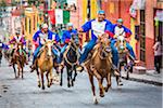 Men on horseback wearing traditional clothing during the historic horseback parade celebrating Mexican Independence Day in San Miguel de Allende, Mexico