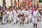 Men in traditional clothing walking through the streets re-enacting the historic peasant revolt for Mexican Independence Day celebrations in San Miguel de Allende, Mexico