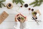 Preparation christmas gifts on a white wooden table with fir branches