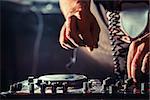 Disc jockey at the turntable. DJ plays on the best, famous CD players at nightclub during party. EDM, party nightlife concept. Dj hands on the turntables.