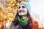 Woman enjoying Christmas time in the city while it is snowing