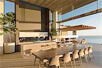 Sunny modern, luxury home showcase interior dining table with ocean view