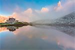 Dolomites Alps, Pale di San Martino reflecting on water with clouds, Baita Segantini, Trentino Alto Adige District, Italy