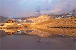 Dolomites Alps, Pale di San Martino reflecting on water with clouds, Baita Segantini, Trentino Alto Adige District, Italy