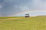 Rainbow and Soviet vehicle driving in the Mongolian steppe. Ovorkhangai province, Mongolia.