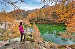 A tourist staring at the small lake near Crampiolo known as Witches Lake, Alpe Veglia and Alpe Devero Natural Park, Baceno, Verbano Cusio Ossola province, Piedmont, Italy