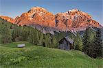 La Valle / Wengen, Alta Badia, Bolzano province, South Tyrol, Italy. Sunset on the pastures of Pra de Rit with the peaks Cima Nove / Neunerspitze and Cima Dieci / Zehnerspitze