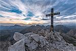 Sesto / Sexten, province of Bolzano, Dolomites, South Tyrol, Italy. The summit cross at the Mount Paterno in the sunset