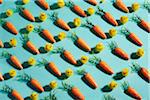 Repetitive carrots and chicken toys setup in rows on a turquoise background