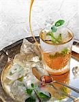 Studio shot of fresh mint iced cocktail on silver tray