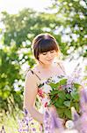 Young woman in field of common lilacs