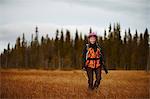 Female hunter walking in field