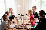 Family with children eating breakfast at table