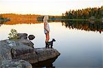 Woman and dog looking at view at lake side