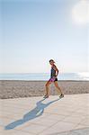 Woman exercising at beach by Mediterranean Sea