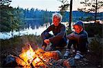 Mother and daughter by a campfire in Gullspang, Sweden