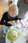 Girl photographing birthday cake with cell phone