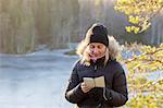 Woman looking at phone in snow